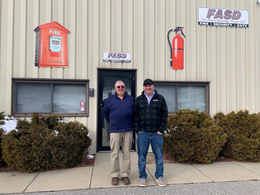 two people standing outside the office building