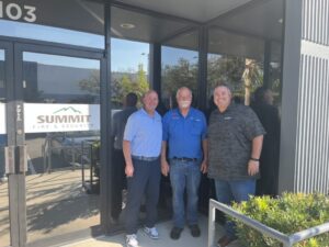 three people standing outside of an office building