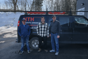 Three men in front of van.
