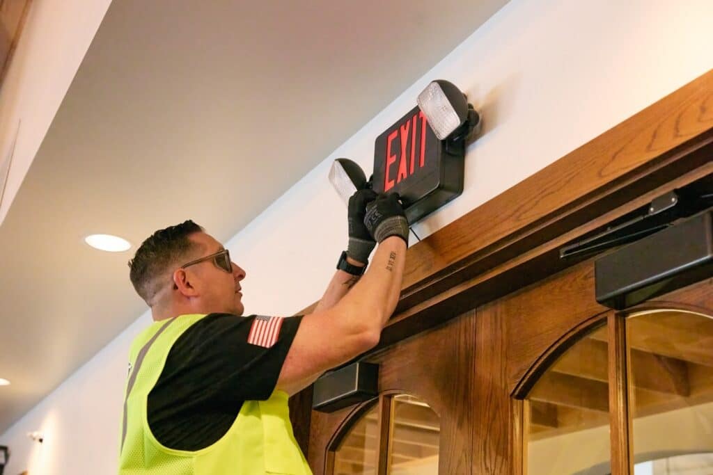 Summit Fire & Security employee inspecting emergency exit signage