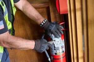 Summit Fire & Security employee completing an inspection of a fire extinguisher