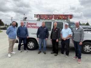 Employees standing next to a Commercial Fire Protection truck.